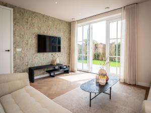 ein Wohnzimmer mit Sofa und Tisch in der Unterkunft Pretty Holiday Home in De Koog Texel with Garden in Westermient + 30 Fotos