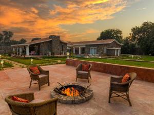 un patio con sedie e braciere di fronte a una casa di amã Stays & Trails Isley, Dhauj Haryana a Dhauj