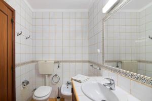 Un baño blanco con inodoro y lavabo. en Estrela do mar, en Santa Luzia 17 fotos más