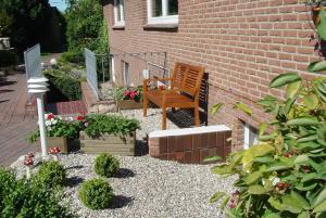 un giardino con panchina e fiori e un edificio in mattoni di Silbermöwe a Fehmarn