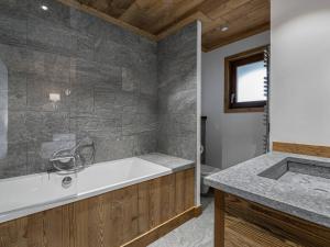 a bathroom with a tub and a sink at Duplex Charmant Près des Pistes avec Hammam et Cheminée à Courchevel Le Praz - FR-1-568-8 in Courchevel