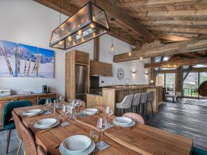 a dining room with a wooden table and a kitchen at Duplex Charmant Près des Pistes avec Hammam et Cheminée à Courchevel Le Praz - FR-1-568-8 in Courchevel +5 photos