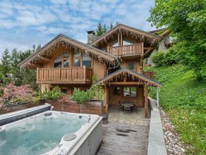 ein großes Holzhaus mit Whirlpool davor in der Unterkunft Chalet familial avec jacuzzi et salle de cinéma - FR-1-565-65 in Les Allues