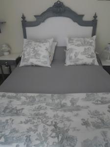 ein Schlafzimmer mit einem Bett mit einer Decke und Kissen in der Unterkunft La Longère de la Combe - Suzanne in Sainte-Même + 12 Fotos