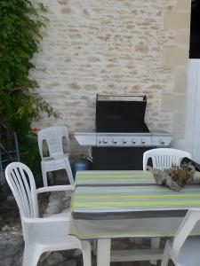 einen Picknicktisch mit zwei Stühlen und einem Herd in der Unterkunft La Longère de la Combe - Suzanne in Sainte-Même