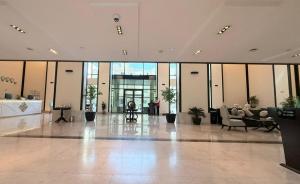 a lobby with chairs and tables in a building at Zara Continental Hotel in Al Khobar