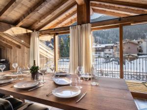 a wooden table with glasses and plates on it with a large window at Spacieux appartement de luxe à Courchevel, proche pistes et commerces, parking inclus - FR-1-568-7 in Courchevel