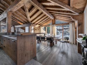 a kitchen with wooden ceilings and a table with chairs at Spacieux appartement de luxe à Courchevel, proche pistes et commerces, parking inclus - FR-1-568-7 in Courchevel