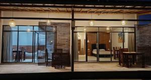 Gili GedeMentari的一间带玻璃门、有一张桌子和一间卧室的房间