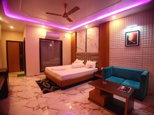 a bedroom with a bed and a blue couch at Coral Beach Resort Mandarmoni in Mandarmoni +54 photos