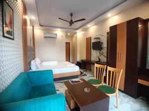 Cette chambre comprend un lit, un canapé et une table. dans l'établissement Coral Beach Resort Mandarmoni, à Mandarmoni