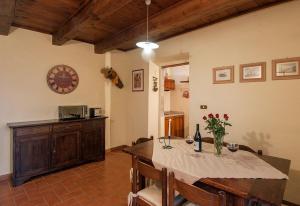 ein Esszimmer mit einem Tisch und einer Uhr an der Wand in der Unterkunft Rustikales Natursteinhaus in der Toskana mit großem gemeinschaftlich genutzten Pool - b60232 in Pratovecchio