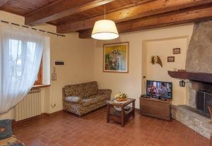 ein Wohnzimmer mit Sofa und Fernseher in der Unterkunft Rustikales Natursteinhaus in der Toskana mit großem gemeinschaftlich genutzten Pool - b60232 in Pratovecchio