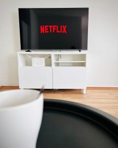 Uma televisão sobre um móvel branco com o logotipo da Netflix. em Spacious two-room apartment with sauna em Varkaus mais 3 fotografias