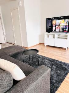 uma sala de estar com um sofá e uma TV em Spacious two-room apartment with sauna em Varkaus