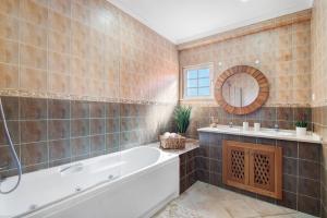 une salle de bain avec une baignoire, un lavabo et un miroir dans l'établissement Vila Picota, à Cerro da Zorra 23 autres photos