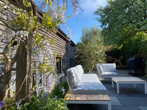 Un patio con dos sillas blancas y una mesa. en Beautiful Oak-framed Devon Escape Near Dartmouth, en Stoke Fleming