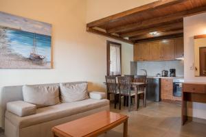 a living room with a couch and a kitchen at To Mpalkoni in Chorefto