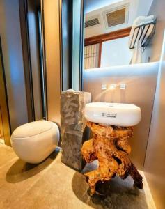 een badkamer met een toilet naast een boomstronk bij Guilin Xi'an Hotel in Guilin