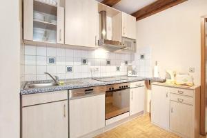 eine Küche mit weißen Schränken und einer Spüle in der Unterkunft Ferienwohnung für 4 Personen  2 Kinder ca 85 m in Waldmünchen, Bayern Bayerischer Wald in Waldmünchen