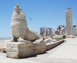 a statue of a sea lion sitting on a sidewalk at RH depto plaza Colón Mdp in Mar del Plata