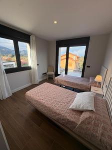1 Schlafzimmer mit 2 Betten und 2 großen Fenstern in der Unterkunft Chalet de lujo la Llavandera , Selnatur in Llanes