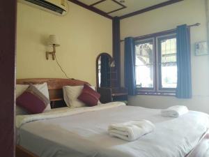 um quarto com duas camas com toalhas em Somphamit Guesthouse em Ban Khon