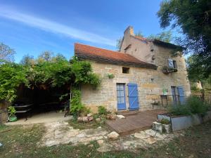 an old stone house with blue doors and a yard at A Pers in Saint-Projet