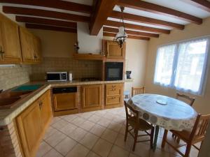a kitchen with a table and a dining room at Le clos des érables in Montesquieu