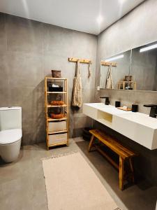 a bathroom with a sink and a toilet and a mirror at Sand and Style, Baie Orientale in Saint Martin