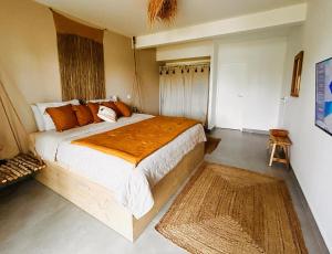 a bedroom with a large bed with orange pillows at Sand and Style, Baie Orientale in Saint Martin