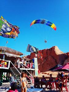 a group of people on a beach flying kites at HospedagemCanoa in Aracati