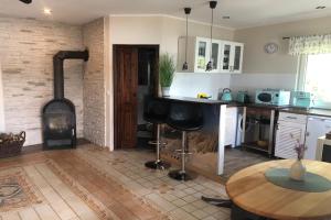 a kitchen with a fireplace and a table and a stove at A wonderful holiday home with lake access in Bieszkowice
