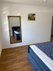 a bedroom with a bed and a mirror at 2 bed room apt with floor heating for business and family travellers in Sindelfingen +11 photos