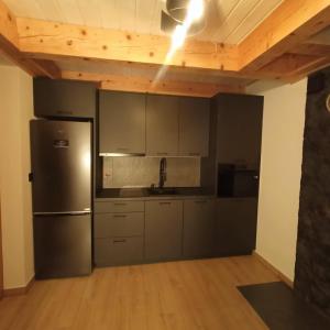 une cuisine avec un réfrigérateur en acier inoxydable et des plafonds en bois dans l'établissement Miejscówka Werlas, à Polańczyk