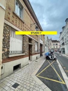 a motorcycle parked on a street next to a building at Studio Rénové - Cœur de Ville WIFI in Dreux