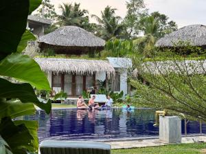 a group of people sitting in the pool at a resort at Shiva Sunrise Resort in Hikkaduwa