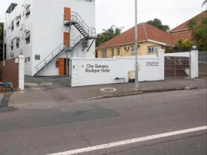 un edificio bianco con un cartello sul lato di una strada di Che Guevara Boutique Hotel a Durban Altre 4 foto