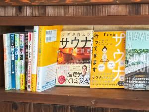 una fila de libros en una estantería en Quan Sea Vista Retreat Japanese Room サウナ付き宿, en Onna