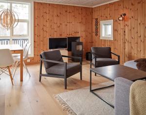 a living room with a table and chairs and a tv at Stranda Fjellgrend 2 bedrooms - 35c in Stranda