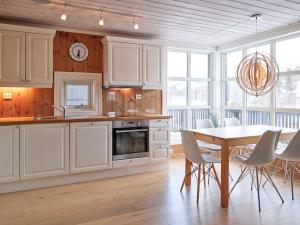 a kitchen with white cabinets and a table and chairs at Stranda Fjellgrend 2 bedrooms - 35c in Stranda