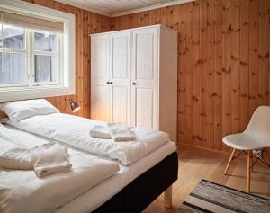 a bedroom with two beds and a cabinet and a chair at Stranda Fjellgrend 2 bedrooms - 35c in Stranda