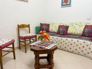 Casa Vacanze - Villa Stefania في بيسكوكوستانزو: غرفة معيشة مع أريكة وكرسيين