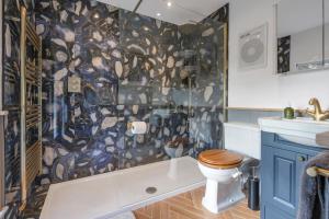 a bathroom with a tub and a toilet and a sink at Spacious 6-Bed Countryside Home Surrounded by Nature in Sutton Bridge +21 photos