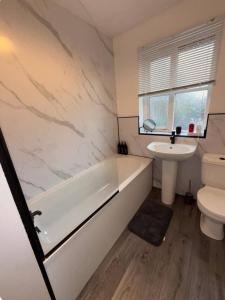 Family & Contractor Stay WiFi, Garden Private Parking for 2 cars في هال: حمام مع حوض استحمام ومغسلة ومرحاض