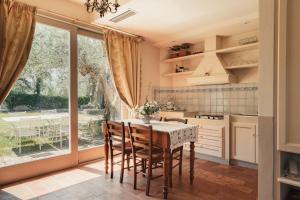 eine Küche mit Tisch und Stühlen und einem großen Fenster in der Unterkunft Geräumige Zweizimmerwohnung in Pesaro