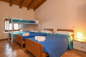 2 Betten in einem Zimmer mit blauer Bettwäsche in der Unterkunft Appartamento 2Camere in Moniga + 27 Fotos