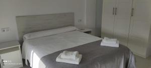 a bedroom with a bed with two towels on it at APARTAMENTO TURISTICO EN LEBRIJA in Lebrija