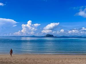 a person standing on a beach near the water at Phuket Patong Buri Resort in Patong Beach +55 photos