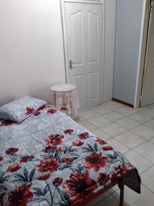 a bedroom with a bed with a floral comforter at The Pasture Loft in Mokopane